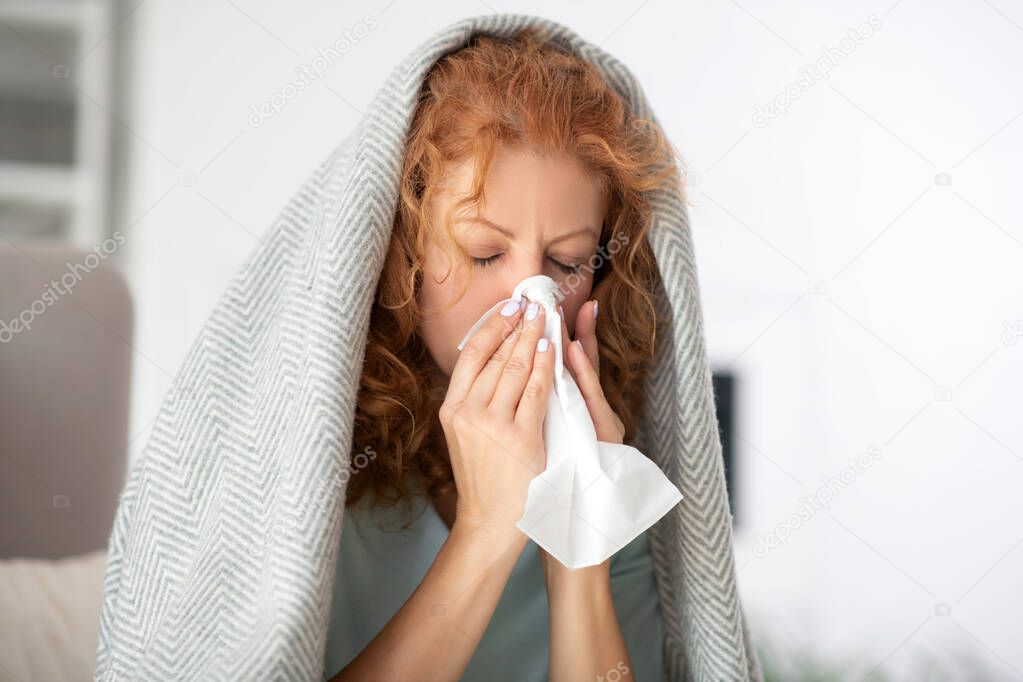 Woman with brassy hair sneezing and coughing all day