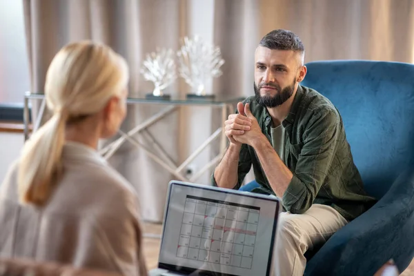 Dark-eyed man feeling better while talking to psychologist