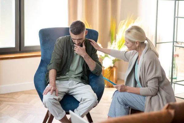 Psychologist touching shoulder of client while supporting him — Stock Photo, Image