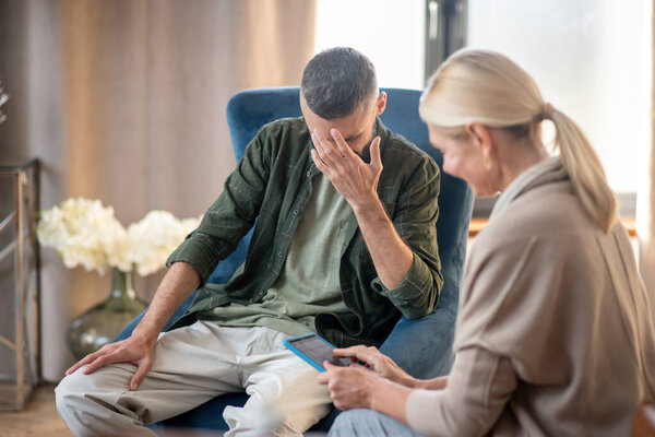 Blonde-haired psychoanalyst helping a man with depression
