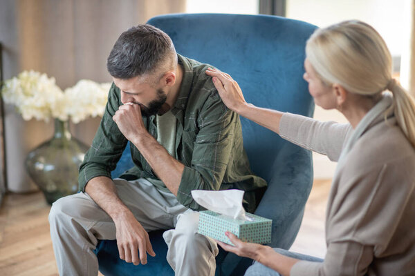 Bearded man crying while thinking about stressful childhood
