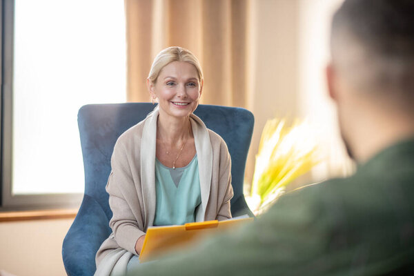 Beautiful psychoanalyst smiling while talking to client