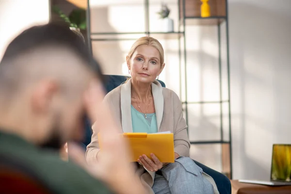 Erfahrener Psychologe hört dem Klienten aufmerksam zu — Stockfoto