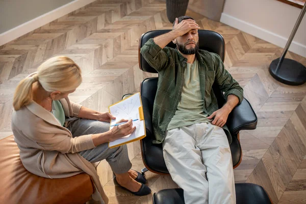 Bearded man röra huvudet när du besöker psykolog — Stockfoto