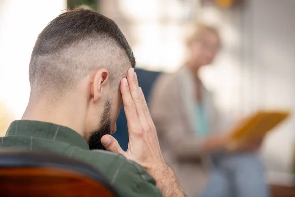 Nahaufnahme eines Mannes, der den Kopf berührt, während er unter Kopfschmerzen leidet — Stockfoto