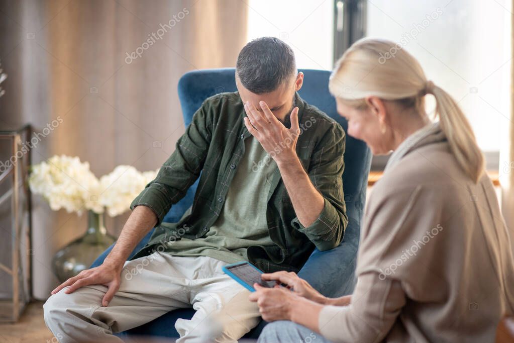 Blonde-haired psychoanalyst helping a man with depression