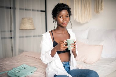 Sabahları acele etmeden kahveden zevk alan bir kadın.