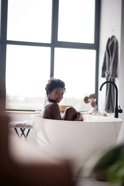 Dunkelhaarige Frau mit Bad im großen Badezimmer — Stockfoto