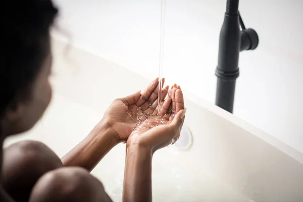 Donna dalla pelle scura che ama l'acqua godendo del tempo in bagno — Foto Stock