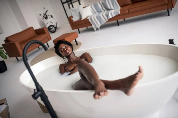 Kręcone długonogi kobieta mając kąpiel w luksusowym mieszkaniu — Zdjęcie stockowe