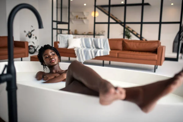 Donna riccia che si rilassa in bagno in appartamento moderno di lusso — Foto Stock