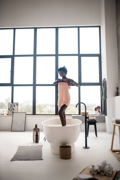 Donna felice dopo aver fatto il bagno in piedi vicino a una finestra enorme — Foto Stock