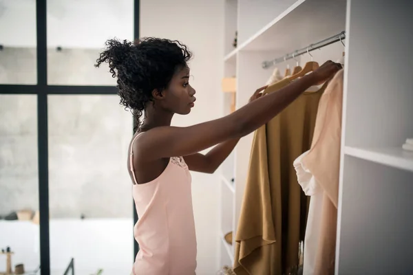 Lockige dunkelhäutige Frau wählt Outfit für den Tag — Stockfoto