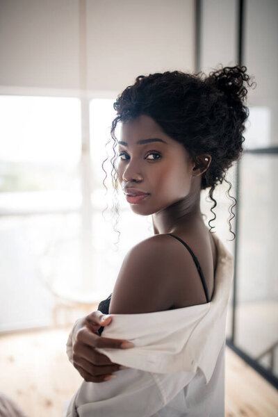 Женщина взволнована, одевая блузку
