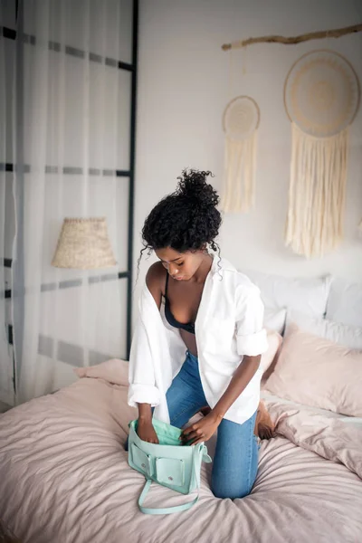 Vue du dessus de la femme mettant tout dans le sac à main — Photo