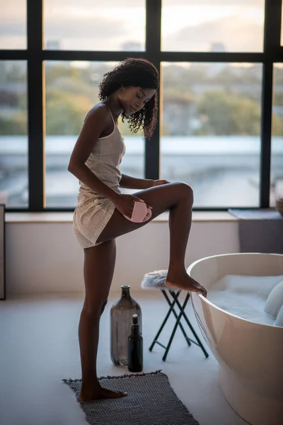 自宅でスパ手順を楽しむスリム暗い肌の女性 — ストック写真