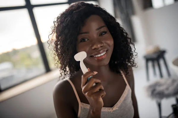 Весела темношкіра жінка чистить шкіру вранці — стокове фото