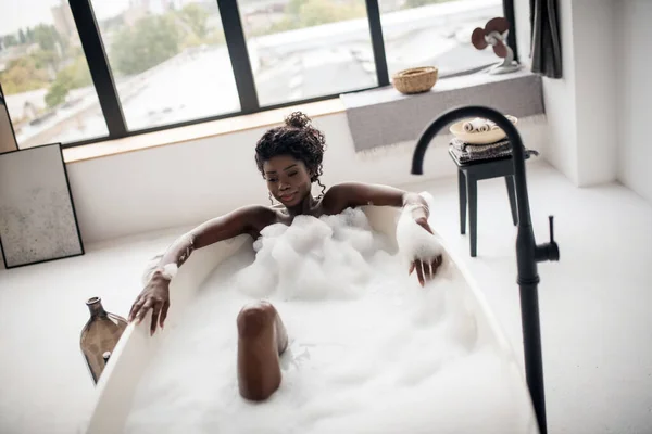 Blick von oben auf schlanke junge Frau beim Entspannen in schäumendem Bad — Stockfoto