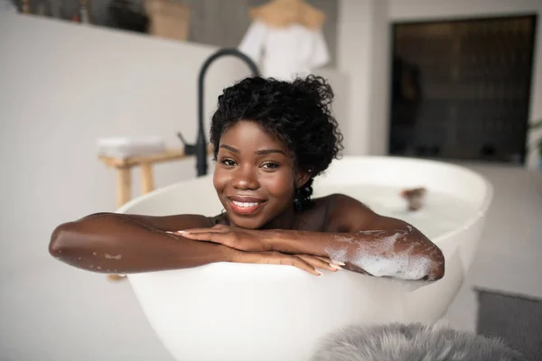 Boldog nő mosolyog, miközben hűvös fürdőben nő — Stock Fotó