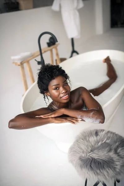 Темноглазый женщина отдыхает в выходные, принимая ванну — стоковое фото