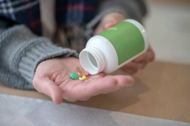 Sabahları haplar ve vitaminler alan erkeklere yakın.
