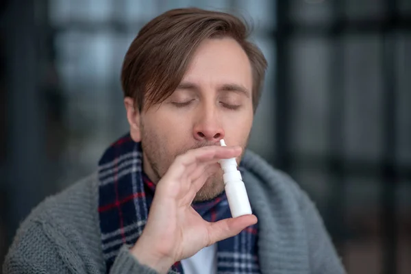 Man using nasal spray suffering from sneezing — Stock Photo, Image