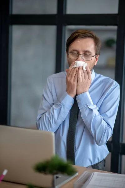 Trabajador de oficina moreno y enfermo estornudando todo el día — Foto de Stock
