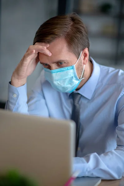 Érett üzletember maszkot visel, miközben betegen jön dolgozni. — Stock Fotó