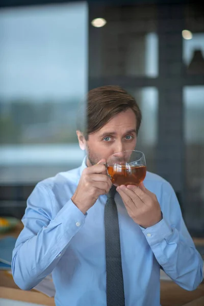 Geschäftsmann trinkt heißen Tee bei Kälte — Stockfoto