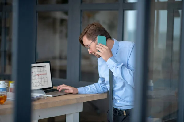 Druk bezig zakenman controleren van zijn schema op laptop — Stockfoto