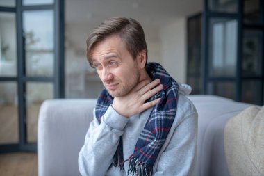 Man touching his neck while having strong cough clipart