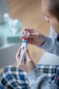 Nezle olurken termometreyi tutan adamın en üst görüntüsü