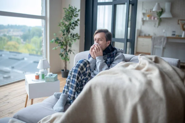 Hombre usando pijamas y bufanda sufriendo de estornudos — Foto de Stock