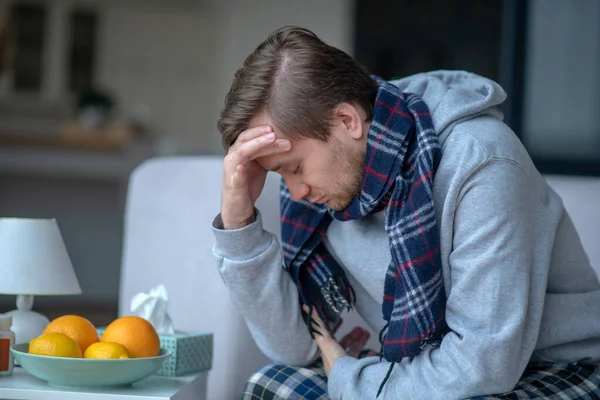 Мужчина в теплой одежде с сильной головной болью — стоковое фото
