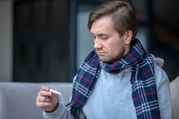 Dark-haired man feeling upset after measuring temperature — Stock Photo, Image