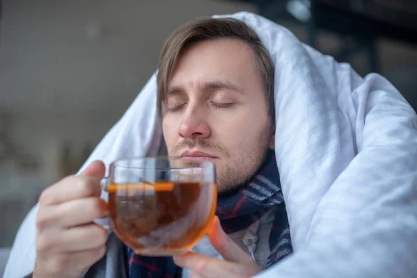 Hombre enfermo bebiendo té negro caliente mientras tiene gripe — Foto de Stock
