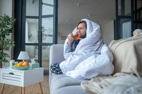 Malade passer la journée dans le salon tout en buvant du thé — Photo