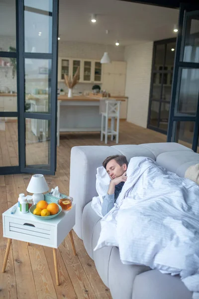 Hombre durmiendo mientras tiene gripe y sintiéndose agotado — Foto de Stock