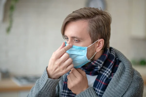 Hombre de ojos azules usando máscara mientras tiene infección — Foto de Stock