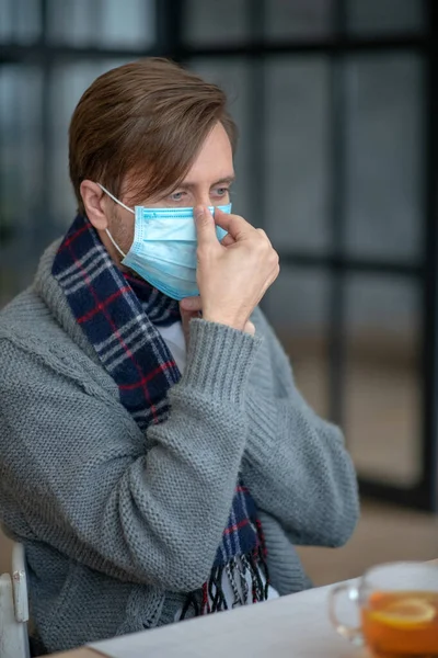 Hombre usando máscara protectora mientras tiene gripe — Foto de Stock