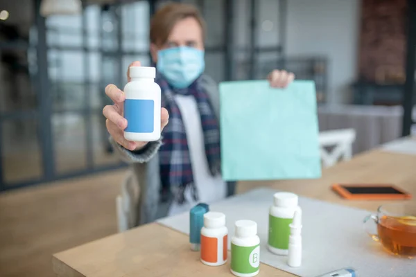 Homem segurando pacote com vitaminas depois de obter a entrega de medicação — Fotografia de Stock