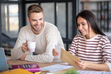 Mutlu çift, eski dostundan gelen mektubu okumadan önce gülümsüyor.