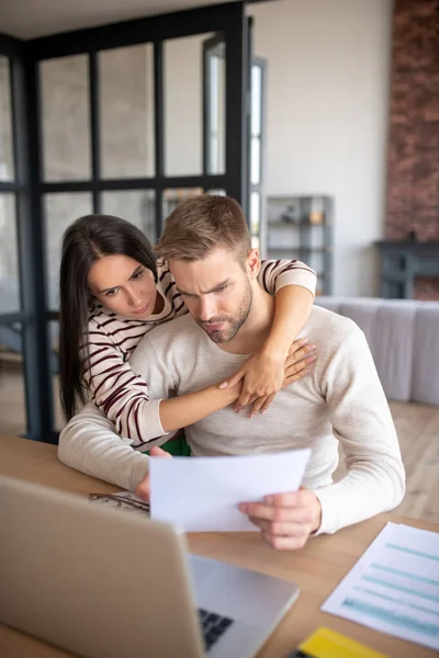 Esposa abraçando marido tendo algumas dificuldades com o negócio — Fotografia de Stock