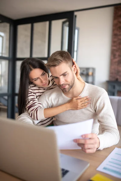 Älskade fru rör vid sin man samtidigt som hon stöder honom — Stockfoto