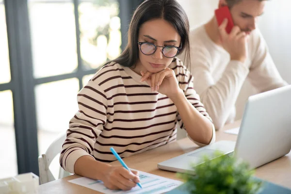 Wife wearing glasses feeling busy while filling tax declaration — Stock Photo, Image