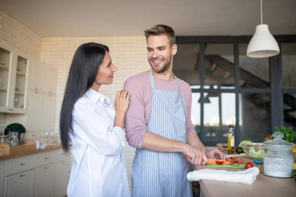 Beaming husband cooking breakfast for his lovely wife — Stock Photo, Image