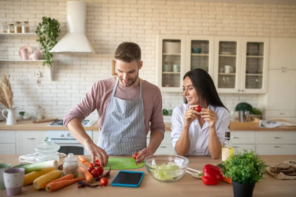 Marido rebanando verduras mientras cocina para su esposa — Foto de Stock