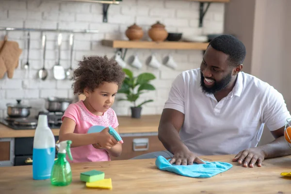 Αφρο-Αμερικανός γενειοφόρος άντρας και η κόρη του καθαρίζουν μαζί και νιώθουν υπέροχα. — Φωτογραφία Αρχείου