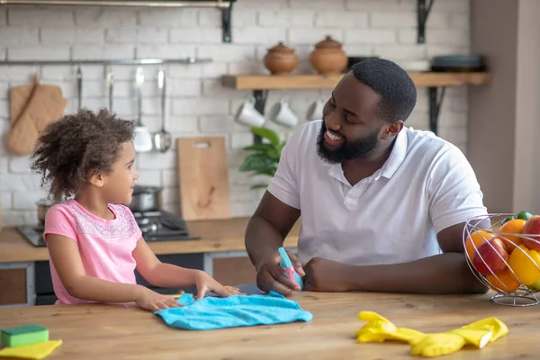 Αφρο-Αμερικανός γενειοφόρος άντρας χαμογελώντας και εξηγώντας πώς να καθαρίσει το παιδί του — Φωτογραφία Αρχείου