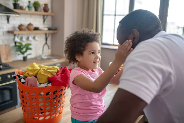 Linda pequeña mulata tocando la cara de sus papás y sonriendo —  Fotos de Stock